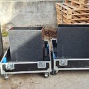 Čtyři černé transportní bedny z překryvního materiálu s kovovými hranami a zámky. Dvě krajní bedny jsou otevřené a v jejich interiéru je vidět modrá…