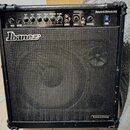 Černý kytarový kombo zesilovač značky Ibanez. V horní části je ovládací panel s nápisy GAIN, BASS, MIDDLE, TREBLE, PRESENCE a VOLUME, dále vstupy CD…