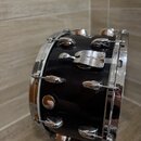 Černý malý buben s chromovaným kováním. Na korpusu je viditelný nápis GRETSCH. Povrch nástroje vykazuje známky opotřebení v podobě drobných škrábanců…