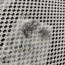 Průhledný plastový sáček s několika malými šroubky. Šroubky jsou tmavé barvy, pravděpodobně z kovu. Žádné značky ani nápisy nejsou viditelné.