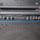 Černý basový kombo zesilovač s logem Fender a nápisem MADE IN USA. Horní ovládací panel obsahuje různé přepínače, potenciometry a grafický ekvalizér…