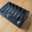 Černý kytarový efekt s nápisem MICROTUBES INFINITY. Na horní straně se nachází pět černých otočných ovladačů s popisky COMPRESSION, DRIVE, TONE • ERA…