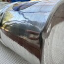Detailní pohled na kovový, stříbrný povrch válcového předmětu. Povrch je pokrytý četnými drobnými škrábánci a známkami opotřebení. V horní části je v…