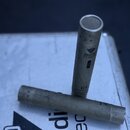 Dvě šedé válcové pomůcky z plastu nebo kovu. Na svisle stojícím kusu je čitelně napsáno „C4“ a nad tím neúplný nápis „Studie Pro...“. Povrch obou pře…