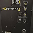 Zadní strana černého studiového monitoru s logem KRK SYSTEMS a nápisem ROKIT 6 POWERED. V horní části jsou tři žluté otočné ovnovnovací knoflíky s po…