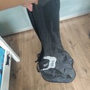 Černý textilní obal na hudební nástroj s rukojetí. Na spodní části je bílý grafický prvek s nápisem HARLEY BENTON. Povrch materiálu je v dolní části…