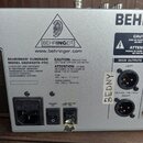 Záběr na zadní stranu stříbrného zařízení s nápisy BEHRINGER a www.behringer.com. Je zde uveden model BEHRINGER® EURORACK MODEL UB2442FX-PRO a inform…