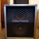 Kytarový reproduktor v hliníkovém rámu s černou mřížkou. Uprostřed mřížky je bílý nápis MESA/BOOGIE. Povrch hliníkového rámu vykazuje drobné oděrky a…