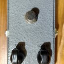 Šedý efekt pedál s texturovaným povrchem. V horní části je nápis British Pedal Company a v dolní části štítek s textem PEPBOX APC RUS. Na horní stran…