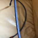 Modrý audio kabel s konektory typu jack. Na povrchu kabelu je bílý nápis EVIDENCE AUDIO • The Siren • SOLID CORE FOR SOLID SOUND. Povrch kabelu vykaz…
