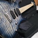 Elektrická kytara s modrým plamenovitým povrchem těla a světlým hnedým hmatníkem. Nástroj má tři humbuckery, chromovaný most a dva ovládací knoflíky.…