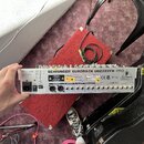 Zadní strana stříbrného rackového zařízení s nápisem BEHRINGER EURORACK UB2222FX-PRO. Jsou zde vidět různé konektory, včetně napájecího vstupu a výst…
