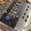 Stříbrný rackový procesor s nápisem Solid State Logic. Zařízení obsahuje řadu otočných potenciometrů, tlačítek a malý displej s textem Entering Silen…
