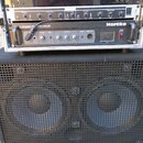 Fotografie zobrazuje basový kombozesilovač složený z rackové hlavy a reproboxu. Na horním zařízení jsou vidět nápisy KORG, Hartke a model LH500 BASS…