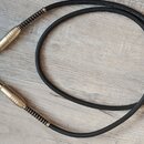 Černý instrumentální kabel s pozlacenými konektory typu jack. Na povrchu kabelu je bílý nápis: Made in Italy, Böfers Noiseless Low Capacity Coaxial c…