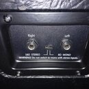 Detail zadního panelu černého zařízení s dvěma jackovými konektory. Nad konektory jsou nápisy Right a Left, pod nimi texty 16Ω STEREO a 8Ω MONO. Mezi…