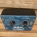 Modrý kytarový pedál s nápisy BluGuitar TONE INNOVATION a BLUBOX SPEAKER EMULATOR IR. Na horní straně jsou dva otočné oválné knoflíky s popisky CAB T…