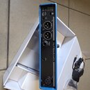 Modrý procesor efektů značky TC HELICON s černým zadním panelem. Jsou zde viditelné konektory OUTPUTS (LEFT, RIGHT), PEDAL, AUX a INPUTS (MIC) s nápi…