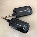 Dvě černé bezdrátové jednotky pro hudební nástroje s kovovými konektory. Horní jednotka má nápisy TRANSMITTER, logo Harley Benton a text AIRBORNE W-2…