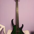 Elektrická basová kytara s tmavě zeleným průsvitným lakem na těle a černou hlavou. Na hlavě je bílý nápis Ibanez. Tělo má výrazné vyřezání a je vybav…