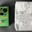 Zelený efekt pedál s nápisy Swollen Pickle, JUMBO FUZZ MkIIs a WAY HUGE BY JEORGE TRIPPS. Na horní straně jsou tři černé otočné oválné knoflíky s pop…