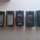 Pět černých a modrých napájecích adaptérů značky BOSS. Každý adaptér má na zadní straně štítek s nápisem BOSS AC ADAPTOR a technickými specifikacemi.…