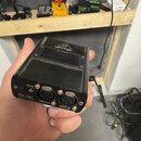 Černý obdélníkový přístroj s logem a nápisem behringer na horní straně. Na zadním panelu jsou dva konektory XLR s popisky INPUT (L) a INPUT (R), vstu…