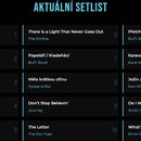 Fotografie zobrazuje textový seznam s nadpisem AKTUÁLNÍ SETLIST. Seznam je rozdělen do tří sloupců a obsahuje celkem 15 číslovaných skladek s uvedený…