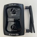 Černý bezdrátový přijímač s dvěma anténami. Na horní části je nápis RELAY G50 RX512 RECEIVER a ve spodní části logo LINE 6. Zařízení obsahuje dva ovr…