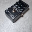 Černý kytarový efekt v kovovém šasi. Na horní straně je nápis METAL MUFF a čtyři ovládací knoflíky. Na boční straně je bílý nápis electro-harmonix NE…