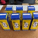 Fotografie zobrazuje sedm modro-žlutých papírových krabiček od elektronkových válv. Na každé krabičce je nápis EL34, text MADE IN CZECHOSLOVAKIA a lo…