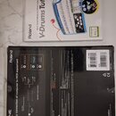 Fotografie zobrazuje dvě krabice od produktů značky Roland. Horní krabice obsahuje software V-Drums Tutor DT-1, spodní krabice USB MIDI rozhraní UM-O…