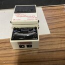 Bílý kytarový ladič značky BOSS s modelem Chromatic Tuner TU-3. Zařízení má černý nášlapný spínač a displej s analogovou stupnicou. Na boku jsou vidi…