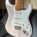 Elektrická kytara s bílým tělem a hnědým dřevěným hmatníkem. Nástroj má bílý pickguard, tři snímače a tři ovládací knoflíky s nápisy VOLUME, TONE a T…