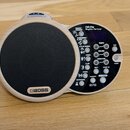 Elektronický doprovodný nástroj v dřevěném provedení s černým mluvčím členem. Na přístroji je uveden nápis BOSS a model DR-01s Rhythm Partner. Ovláda…