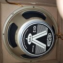Fotografie znázorňuje reproduktor v kartonové krabici. Na středovém štítku je uvedeno logo CELESTION, označení G12, TYPE V a nápis 70-watt. Po obvodu…