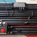 Černý kovový pedálbord s mřížkovým dnem a bočními madly. Na desce je umístěn zdroj s nápisemem Harley Benton POWERPlant ISO-5 Pro POWER SUPPLY a efek…