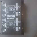 Fotografie zachycuje zadní stranu černé DI boxy s bílým technickým popisem. Na zařízení je uveden nápis RH SOUND DB-02 DIRECT BOX. Jsou zde viditelné…