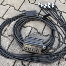 Černý vícežilový kabel s rozbočovacím boxem a čtyřmi konektory na koncích. Na boxu jsou čtyři female XLR konektory s popisky 01, 02, 03 a 04. Kabel j…