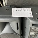 Dva černé aktivní reproduktory z plastu. Na jednom z nich leží manuál s nápisy OPERA LIVE 210, PROFESSIONAL ACTIVE SPEAKER a logem dB TECHNOLOGIES. N…