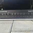 Černý rackový zesilovač s nápisy GLOCKENKLANG a Soul II. Přední panel obsahuje několik vstupů, přepínačů a otočných potenciometrů s popisy Gain, Bass…