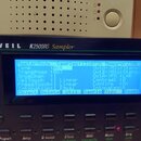 Detailní pohled na ovládací panel sampleru značky KURZWEIL, model K2500RS Sampler. V centru je modrý LCD displej s textovými údaji, včetně nápisů Mas…