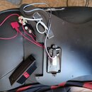 Černý plastový pickguard k elektrické kytáře s připevněnou elektronikou a zapojenými kabely. Na komponentu je viditelný nápis PASSIVE TONE a na bílém…
