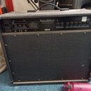 Zadní strana černého kytarového komba s texturovaným povrchem. Na horním panelu je bílý nápis Hughes & Kettner TECHNOLOGY OF TONE ENGINEERED IN ST. G…