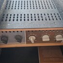 Záběr na přední panel zesilovače v dřevěném šasi s kovovým čelem. Na levé straně je logo a nápis "SIGNAL AUDIO", vpravo je vidět část nápisu "OX". Př…