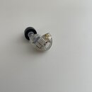 Jedno průhledné in-ear sluchátko s černou silikonovou koncovkou. Uvnitř průhledného plasteku je vidět elektronický modul s bílým nápisem „B800“ a pod…
