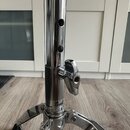 Detail chromovaného stojanu s teleskopickou hřídelí a utahovacím šroubem. Na spodní části trubice je čitelné logo „Pearl“ a nápis „MADE IN JAPAN“. Po…