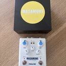 Bílý kytarový efekt s modrými knoflíky a nápisem MASAMUNE —booster & kompressor— a logem NUX. Na pedálu jsou ovládací prvky BOOST LEVEL, BLEND, KOMP…