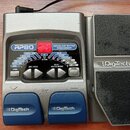 Stříbrný kytarový procesor s modrými spínači a expresním pedálem. Na přístroji je nápis RP80 MODELING GUITAR PROCESSOR a logo DigiTech na pedálu i sp…