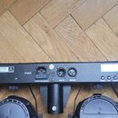 Zadávací panel černého svítícího zařízení s LCD displejem. Jsou zde viditelné nápisy POWER, AC220-240V;50/60Hz, DMX IN, DMX OUT a MIC, spolu s ovláda…